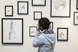 A Luther student views drawings in a gallery.