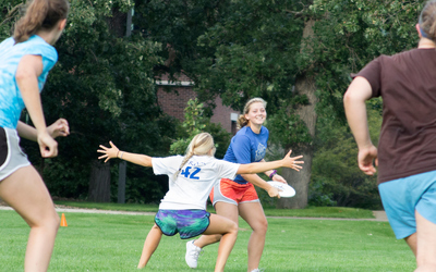 Luther students play a game of Frisbee on the college lawn.