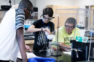 Three students work with a professor in Sampson Hoffland Laboratories.