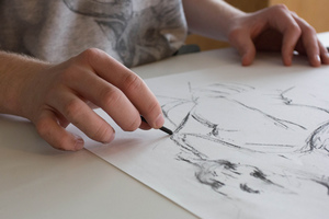 A student draws in a drawing course.