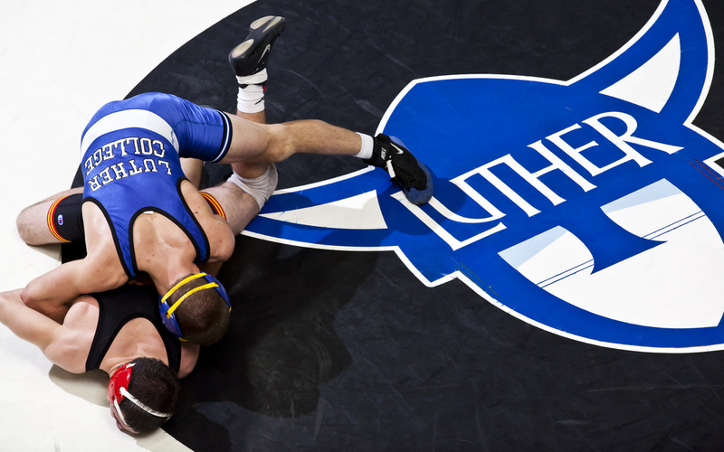 A Bird's-eye view of a wrestling match with the Norse logo on the mat.