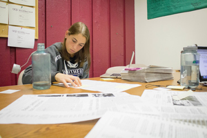 A Luther student makes handwritten edits for Chips Newspaper.