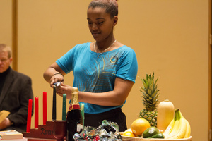 A Luther student lights a candle at the annual Kwanzaa chapel service