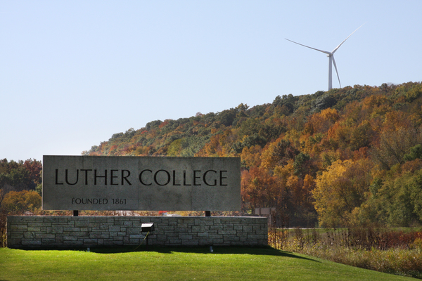 Wind turbine in the Oneota Valley with the Luther College sign