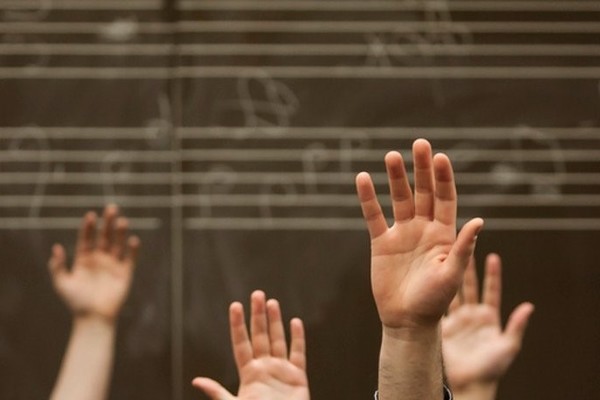 Music students with their hands raised