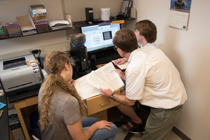 Professor Wilkerson and students Madilyn Heinke '19 and Eric Floden '18 studying star data.