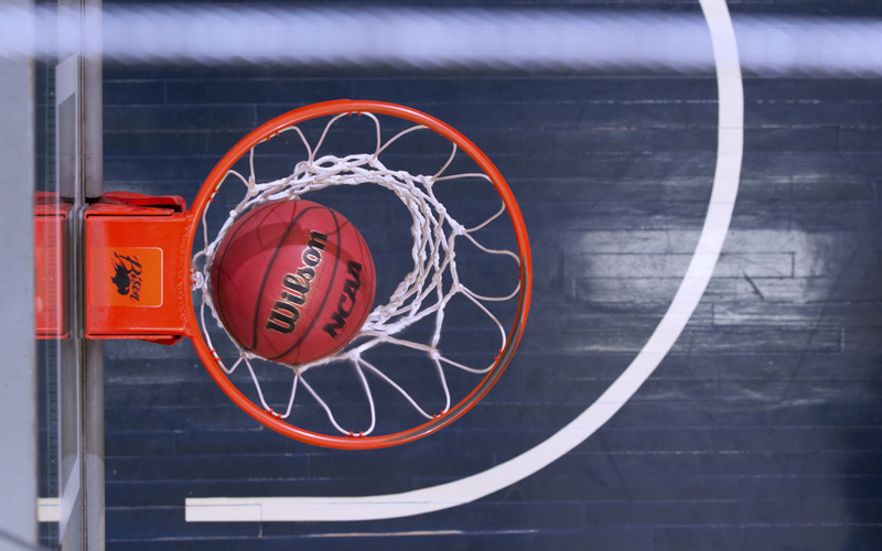 Photo of a basketball in the hoop.