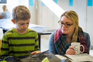A Luther student works with an elementary school student in an art education classroom.